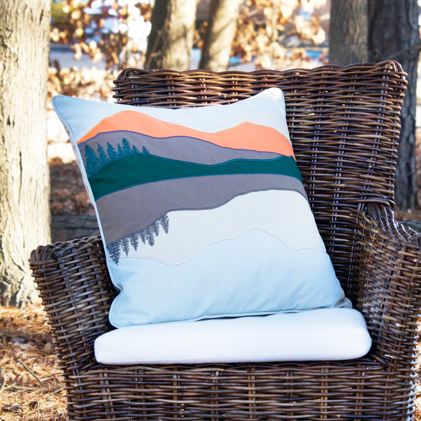Sunset Forest Mountain Pillow outside on a chair