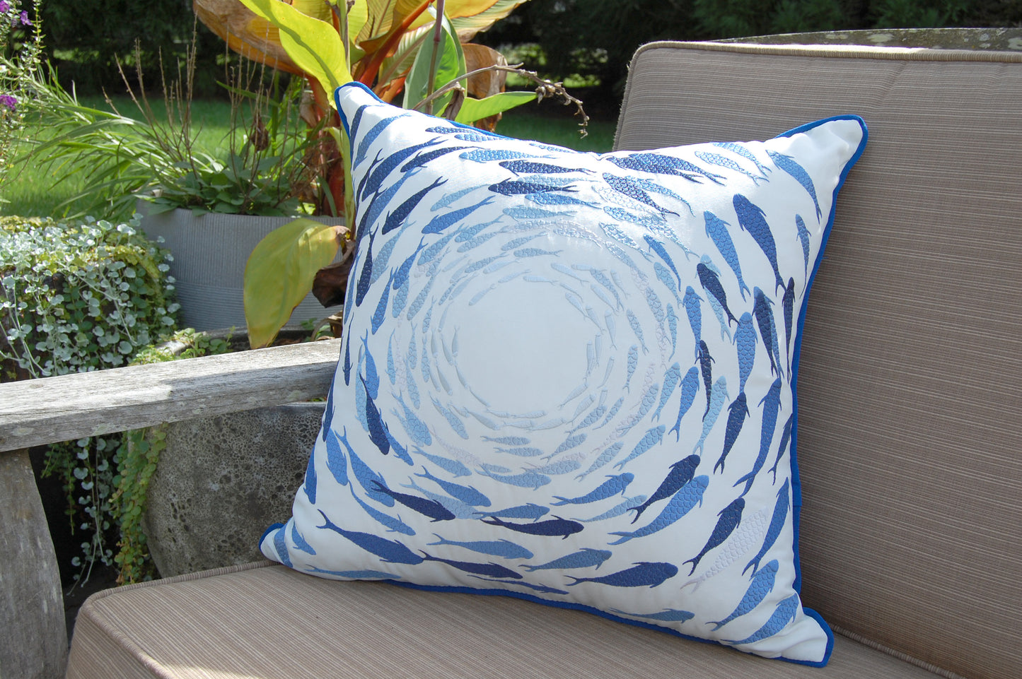 Azure Fish School outdoor pillow pictured on a patio couch.