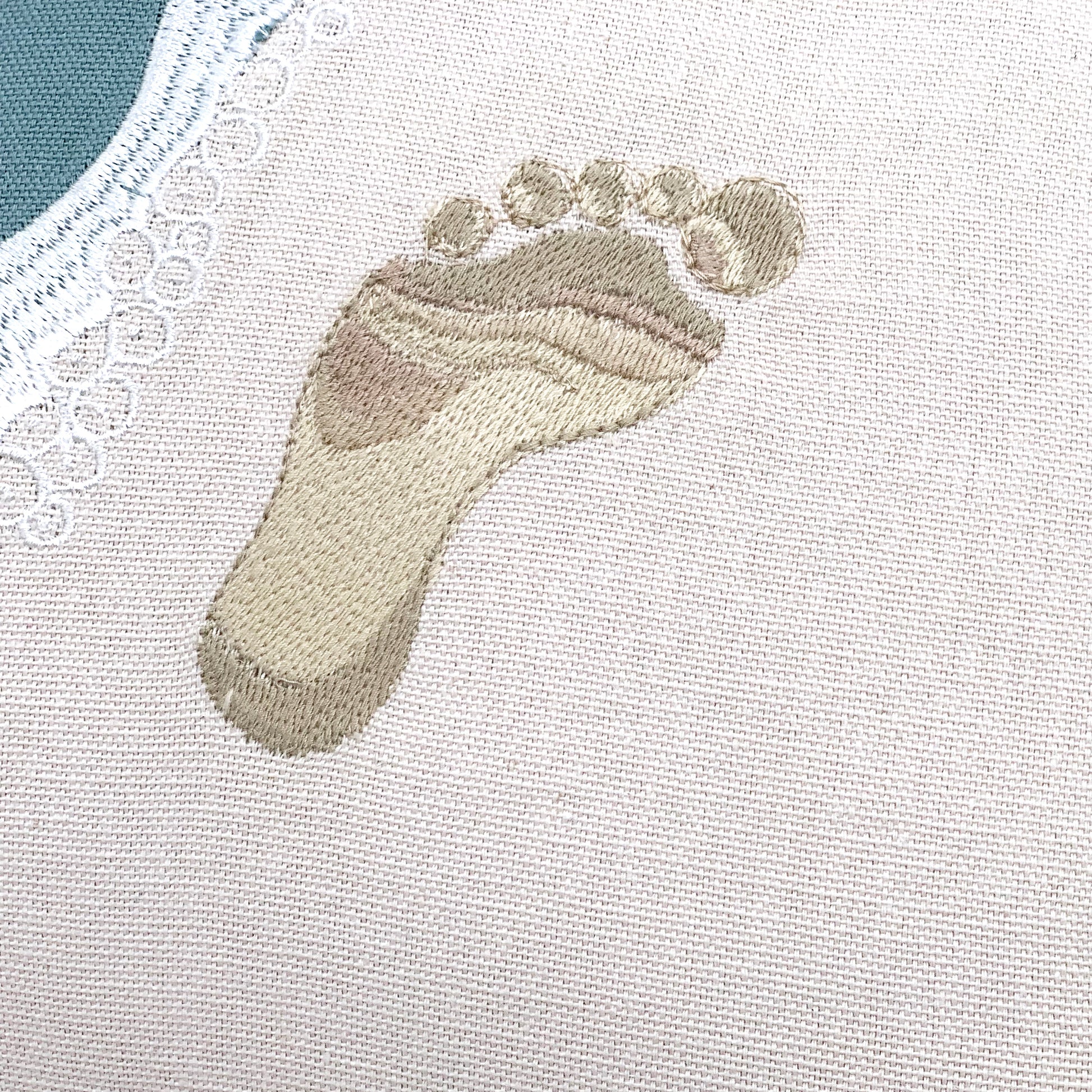Detail shot of the embroidery work on the Best Friends Footprints Lumbar Pillow.