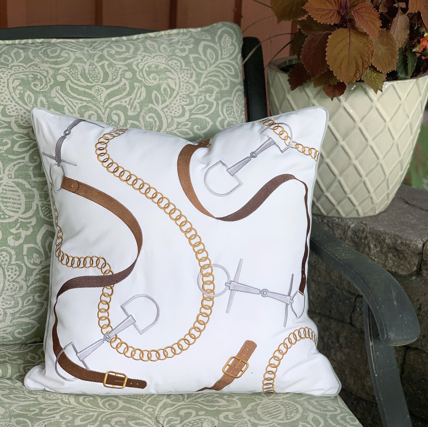 Bits and Leather White outdoor pillow styled on a rod iron bench.