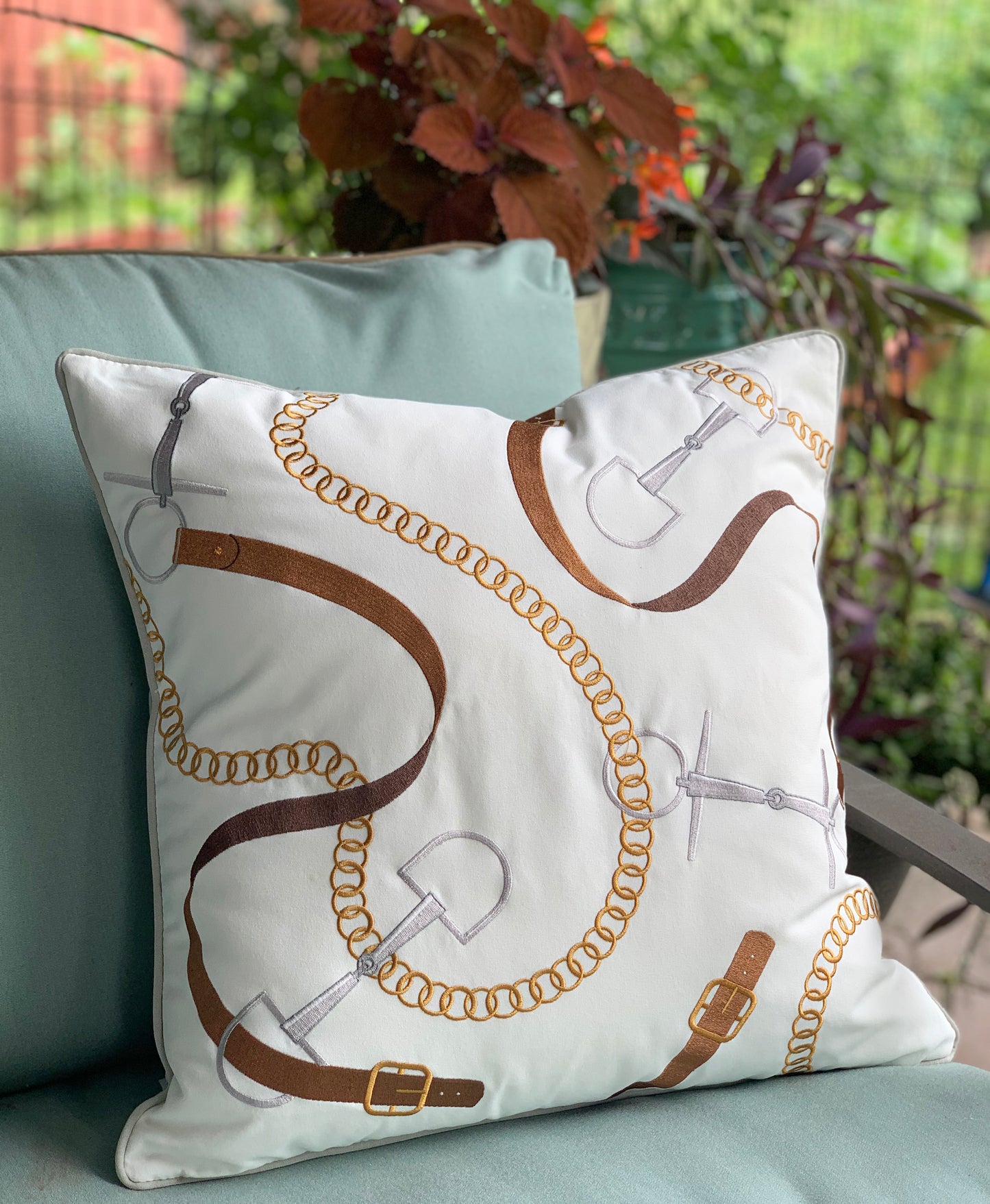 Bits and Leather White pillow styled on an outdoor bench.