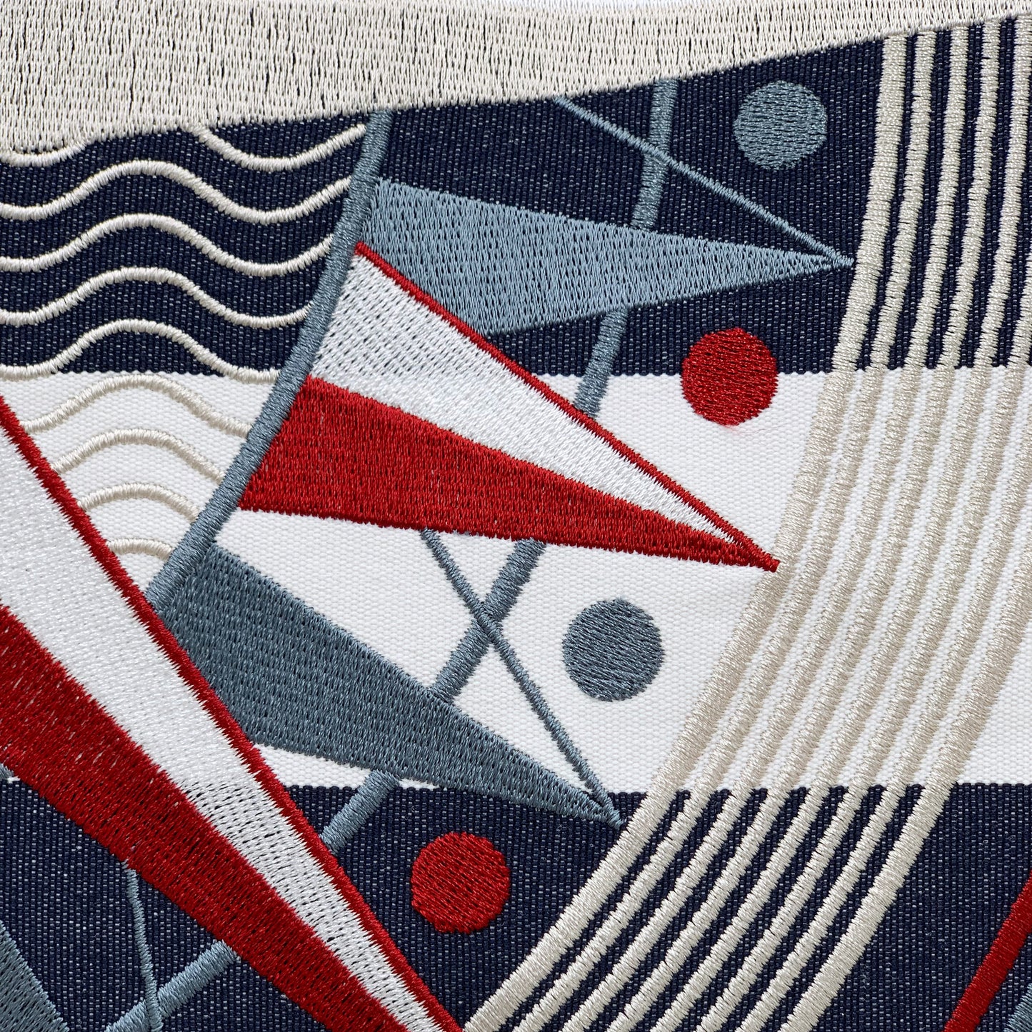 Detail shot of the embroidered compass on the Blue Stripe Compass Rose Pillow.