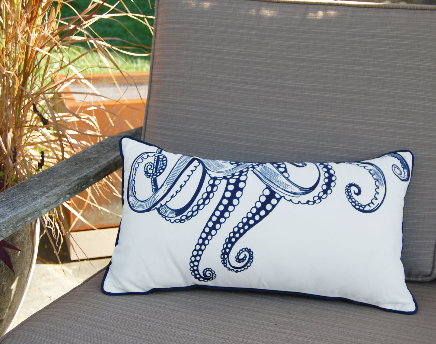 Octopus Tentacles Indoor Outdoor pillow styled on an outdoor patio chair.