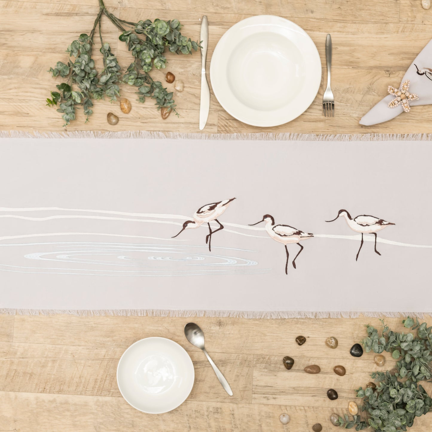 Avocets wading in waves embroidered table runner with fringe.