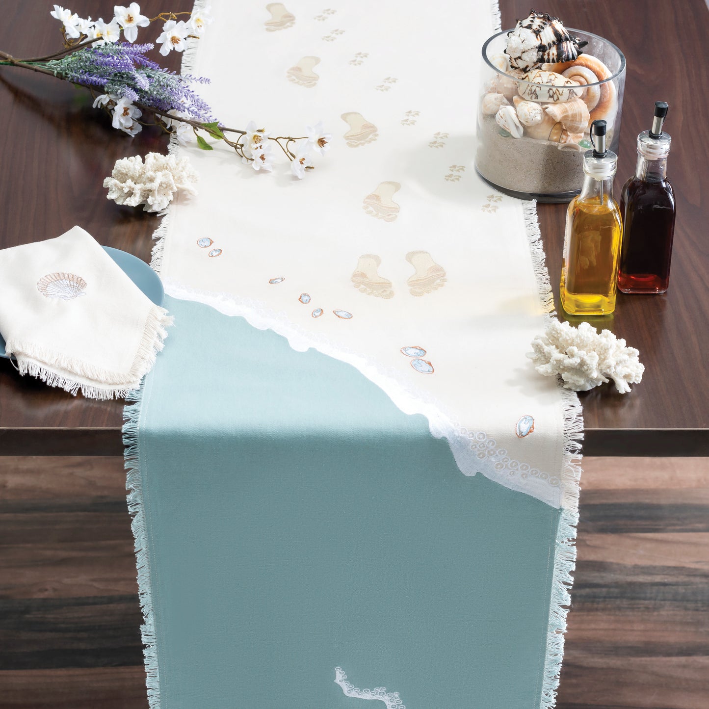 Human and Dog Foot Prints Embroidered Scene Table Runner on Table with Shells, Flowers, and Olive Oil