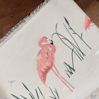 Zoomed in image of embroidered Pink Flamingo and Reeds on a tan cotton background.