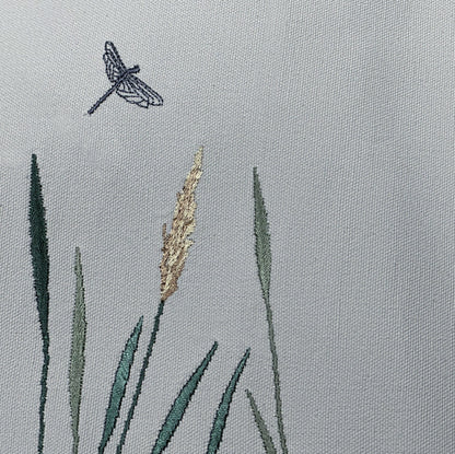 Zoom in detail of embroidery of dragon fly and reeds on Grey Cotton Backing