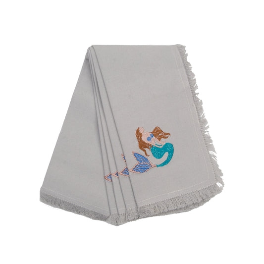 Fringed grey cotton napkins, featuring an embroidered mermaid with brown hair and a turquoise tail.