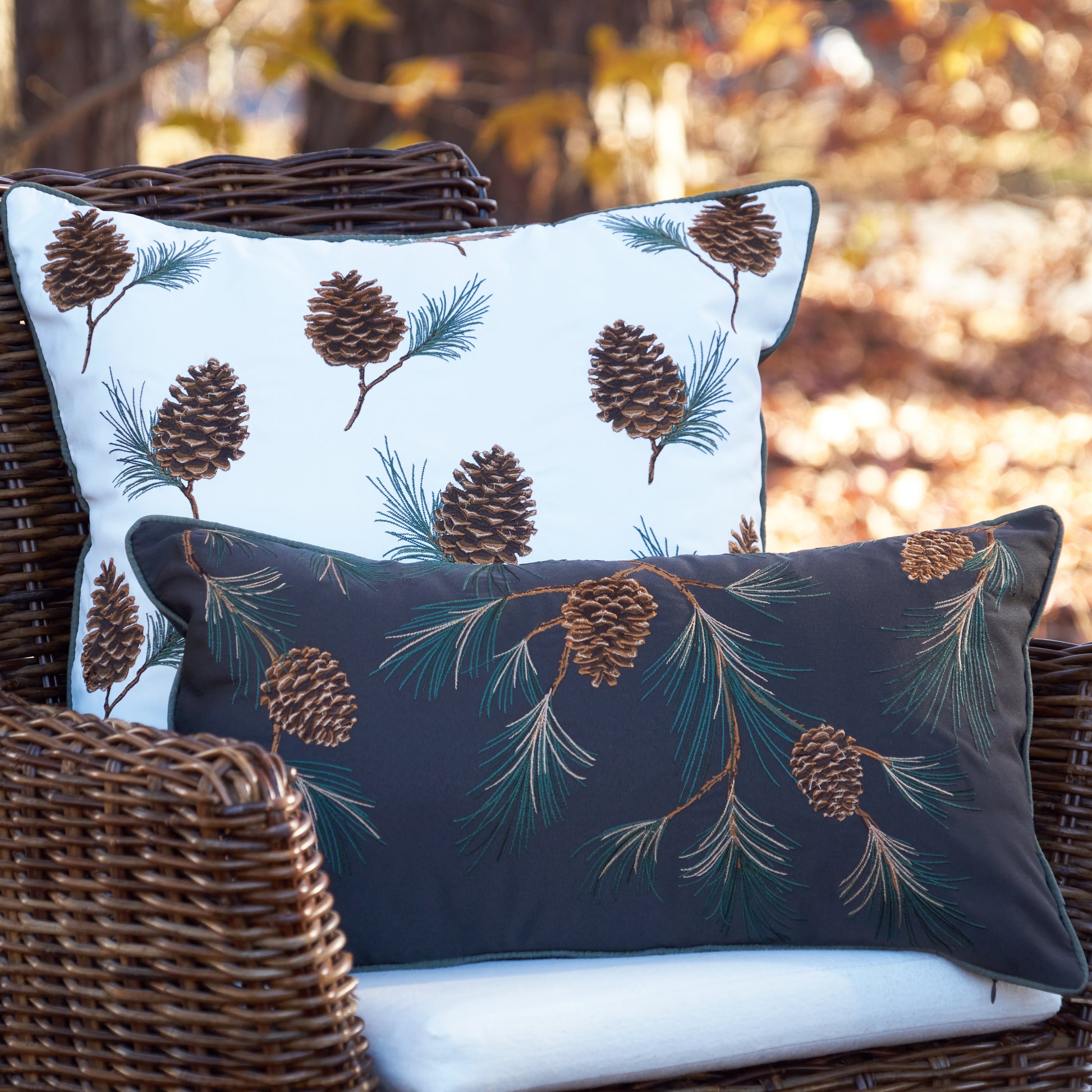 Pine Branch Pattern Lumbar Pillow in front of the Pinecones and Branches Pattern Pillow on a chair outside