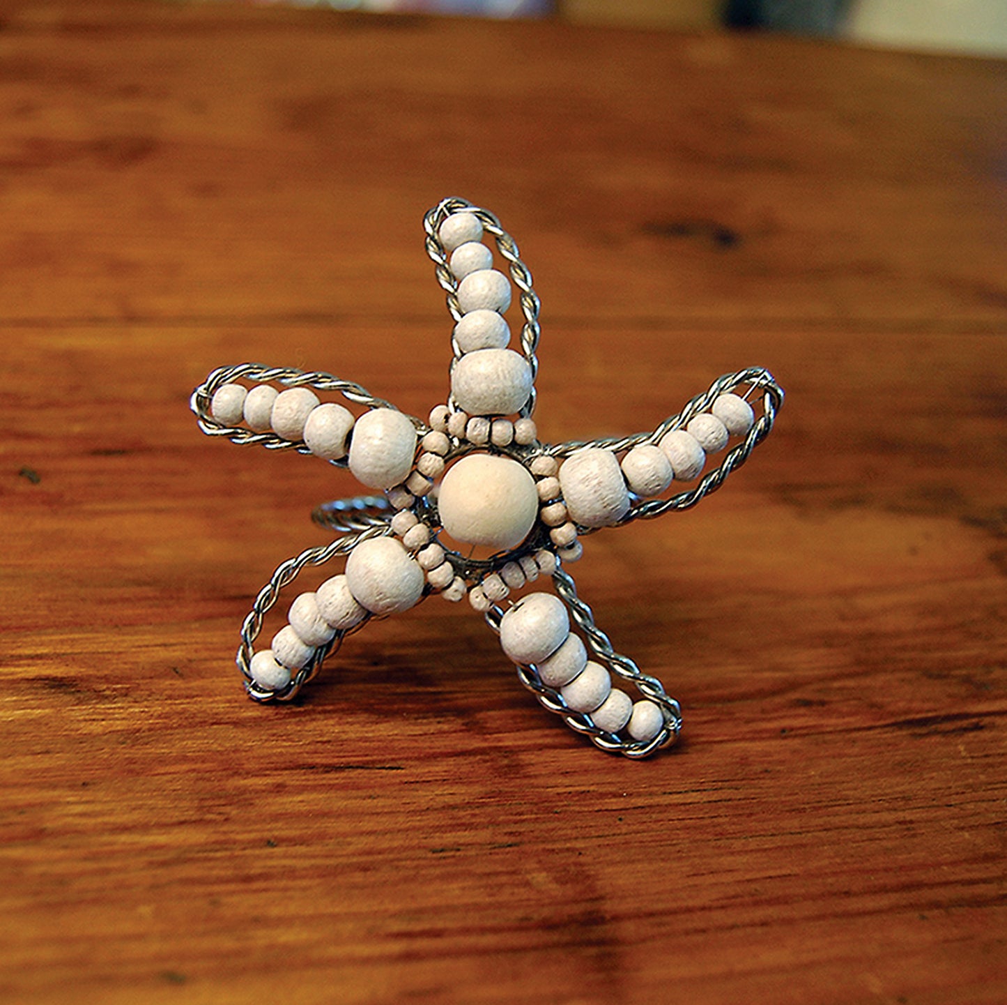 Sea star shaped napkin ring crafted of natural beads.