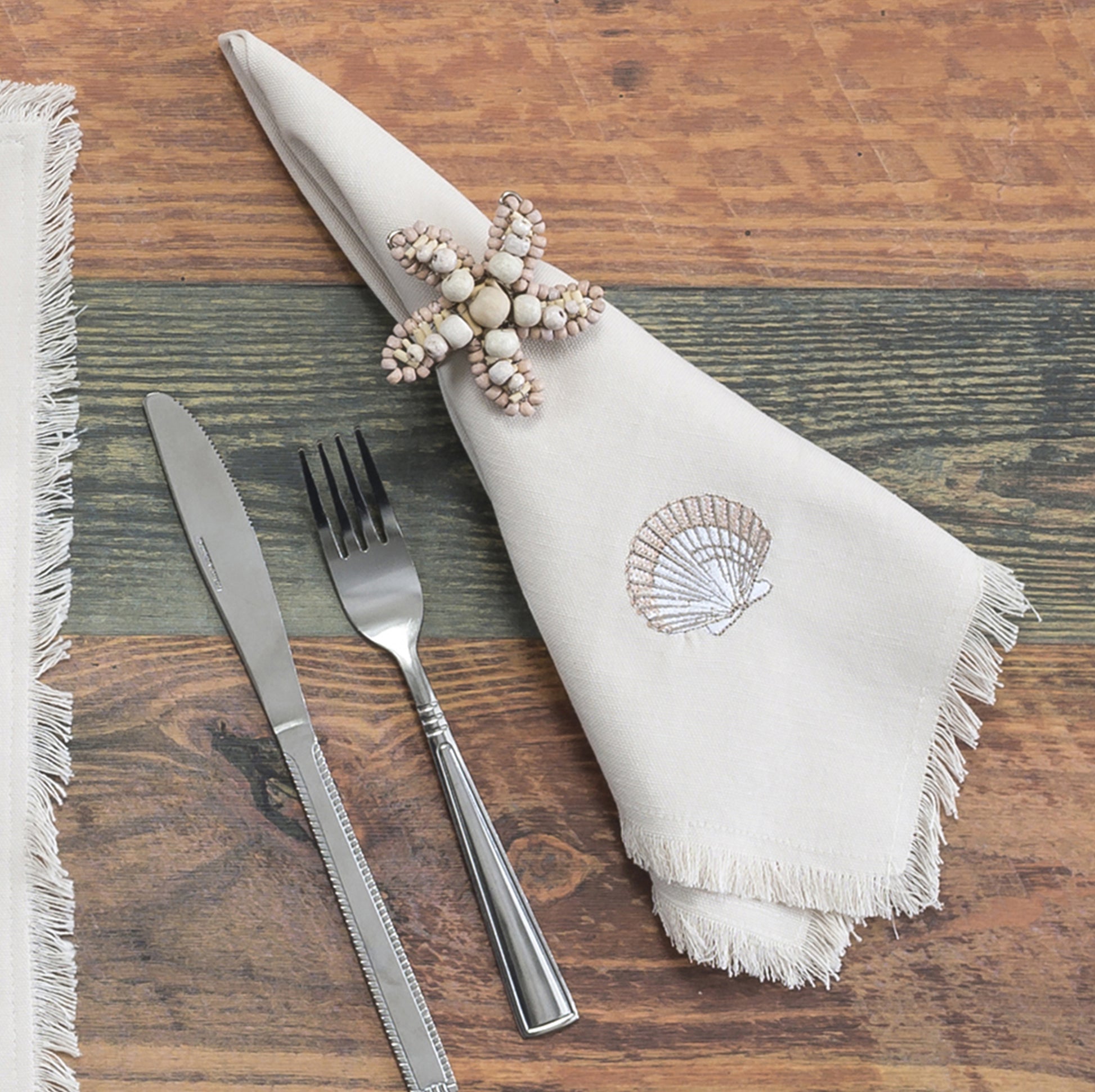Shell napkin wrapped in Sea star shaped napkin ring crafted of natural beads.