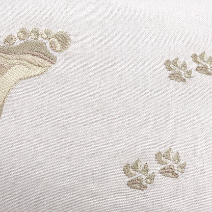 Detail shot of the embroidery work on the Best Friends Footprints Lumbar Pillow.