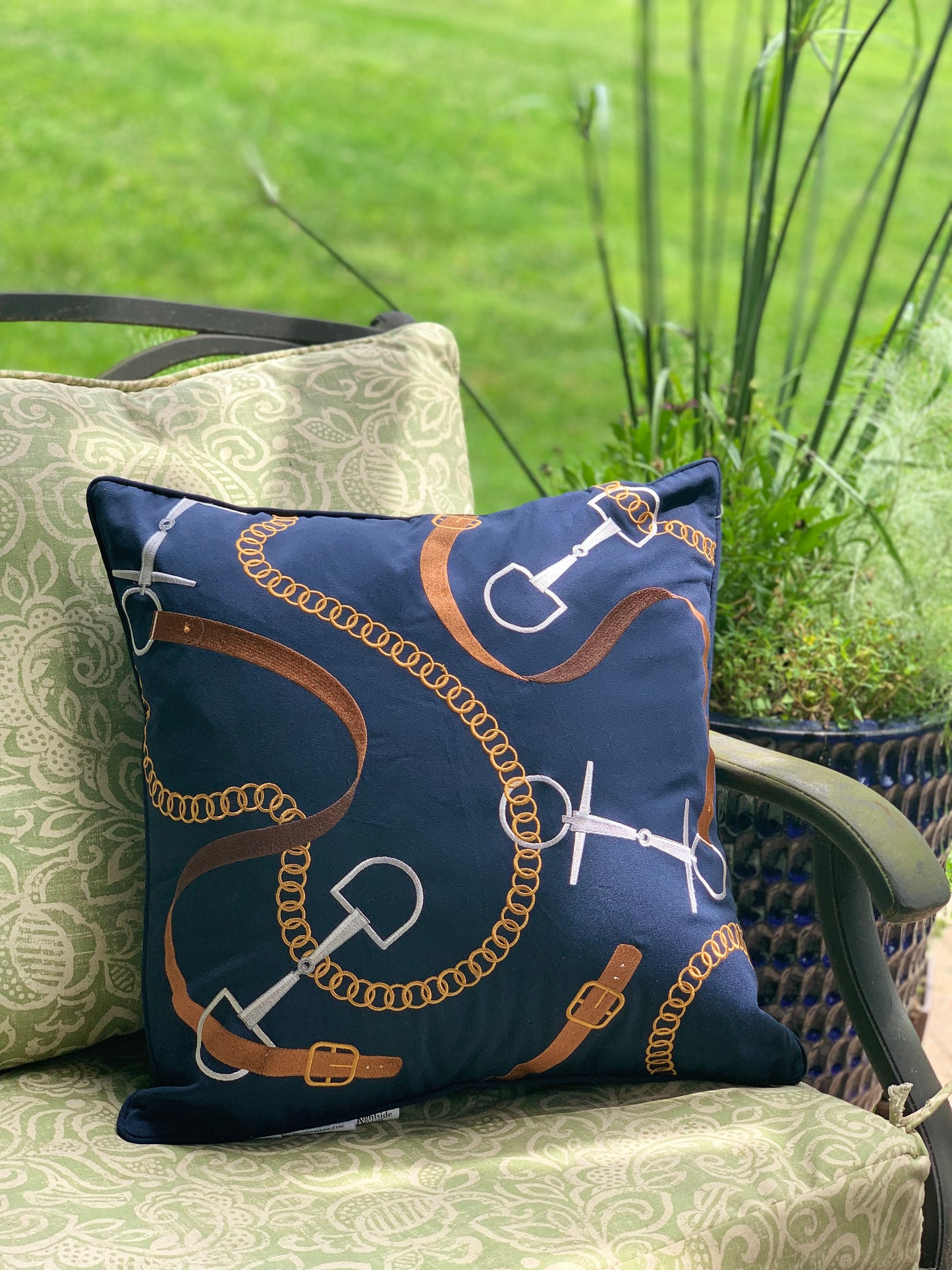 Bits and Leather Navy pillow styled on an outdoor couch.