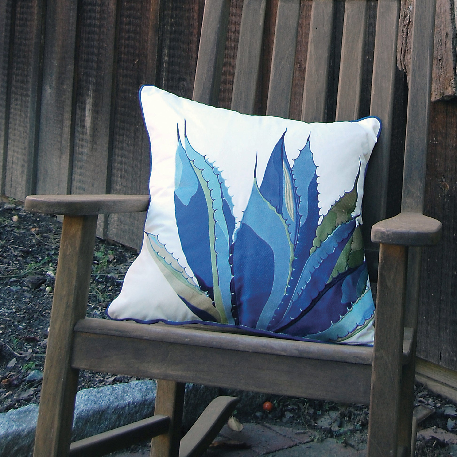 Blue Agave Indoor Outdoor Pillow styled on a wooden rocker.