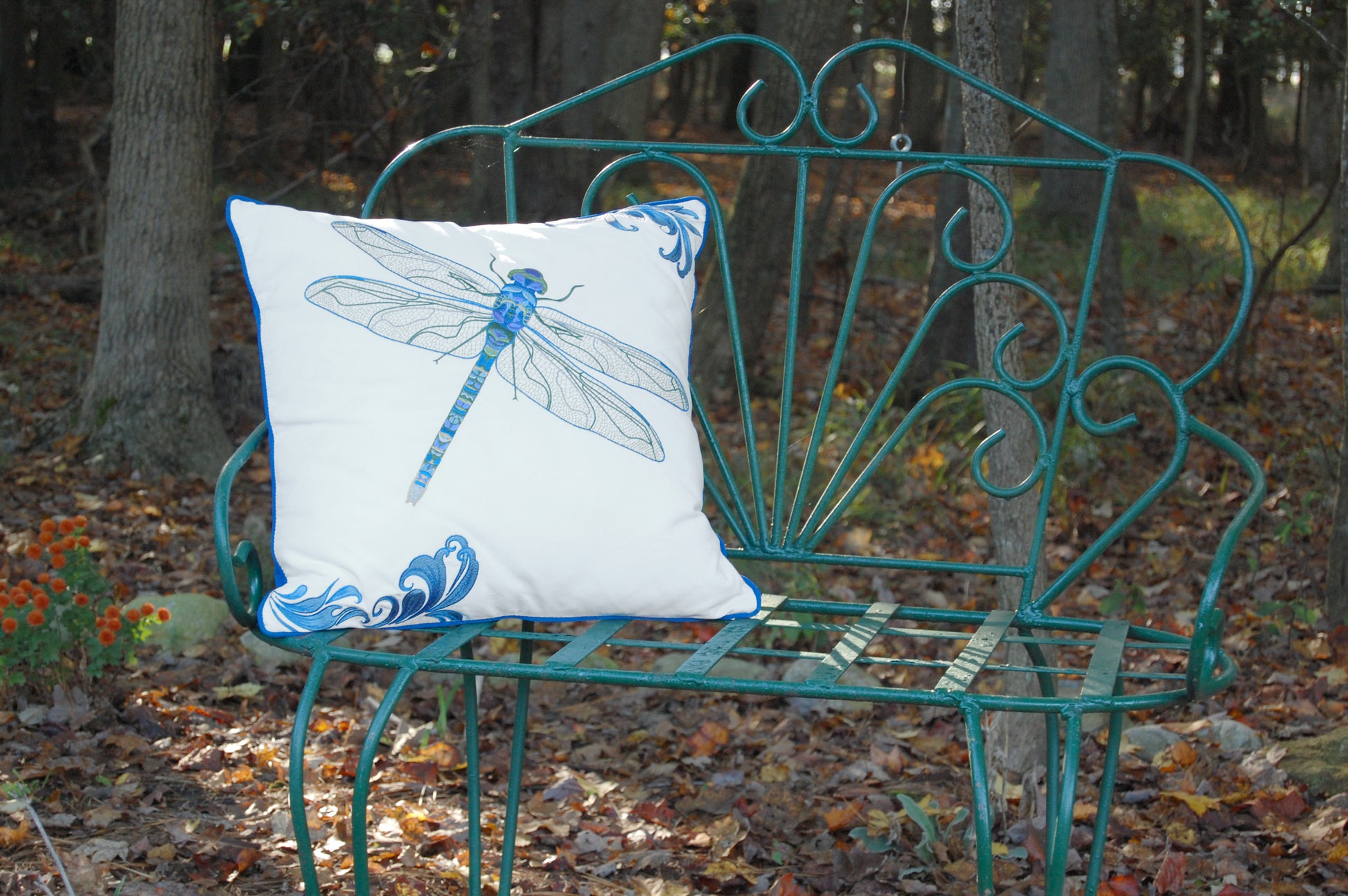 Blue Dragonfly outdoor pillow styled on a metal bench.