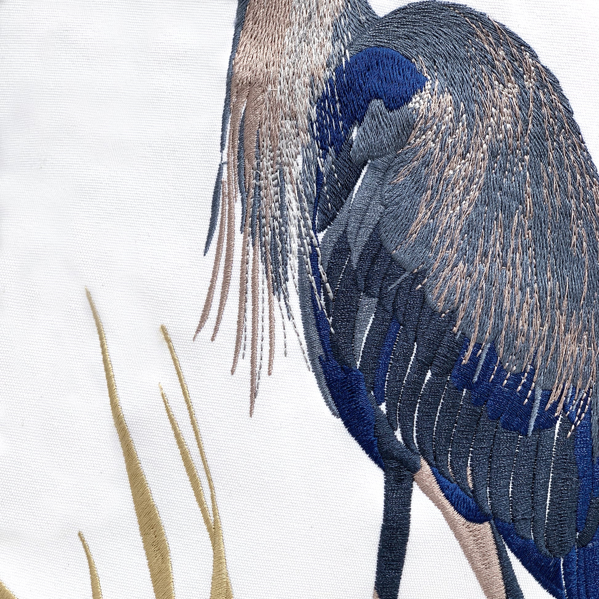 detail shot of the embroidery work on the Blue Heron and Saltmarsh Indoor Outdoor pillow.