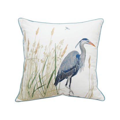 A large blue heron walking through marsh and cattails. Embroidered on a white ground outdoor pillow.