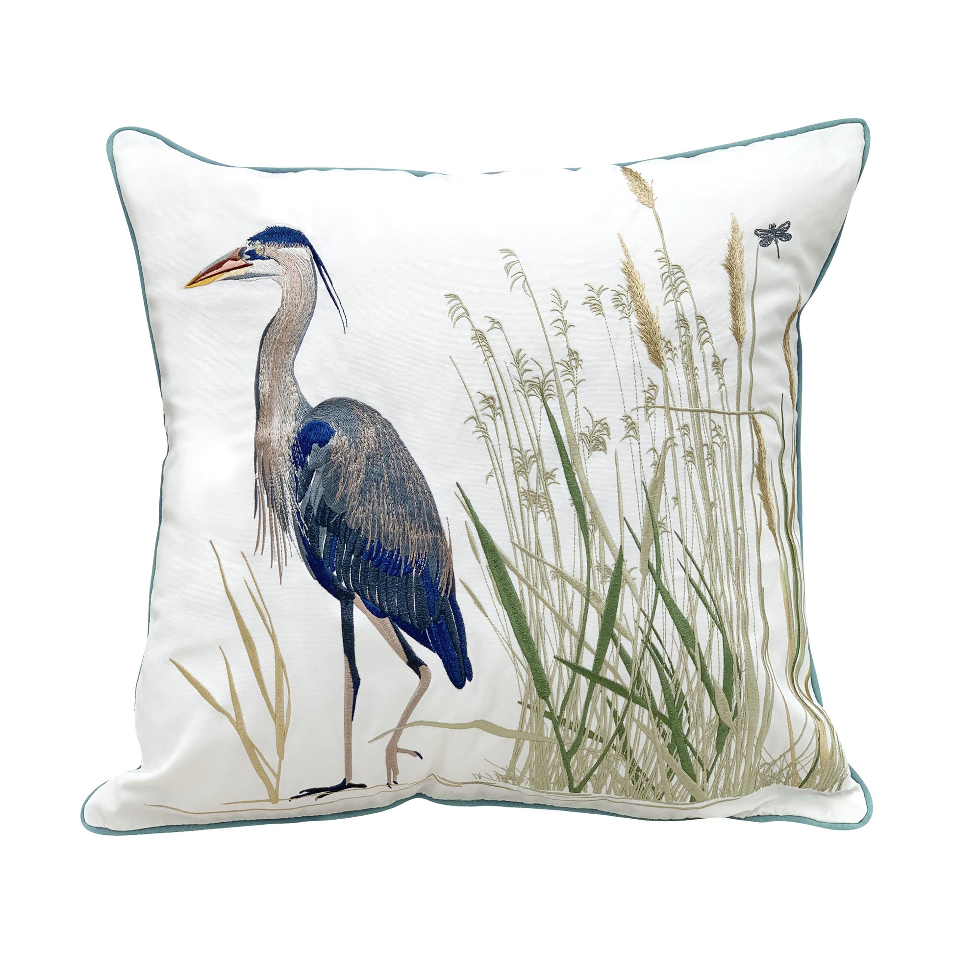 A large blue heron walking through marsh and cattails. Embroidered on a white ground outdoor pillow with blue edge piping.