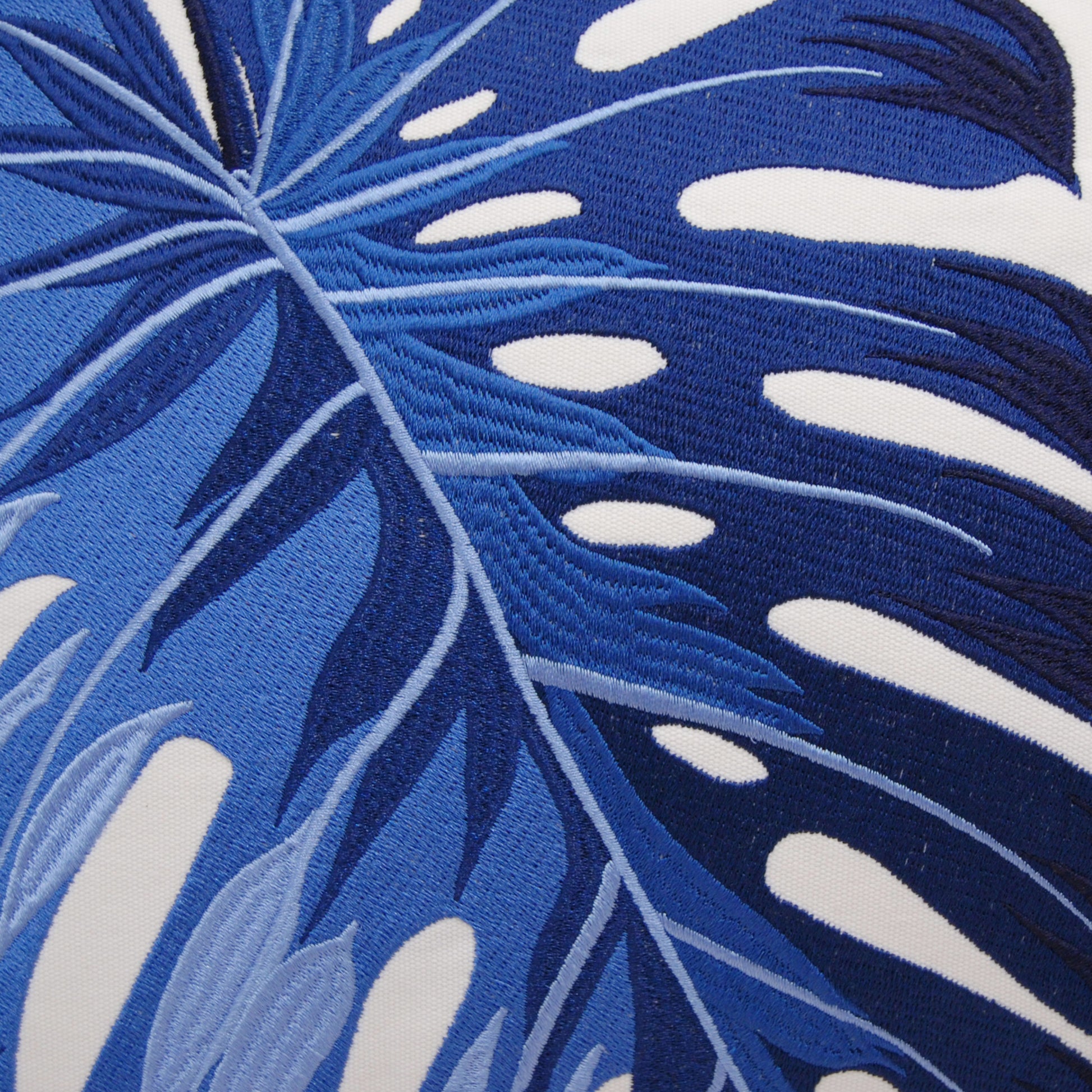 Detail shot of the Blue Monstera Pillow embroidery.