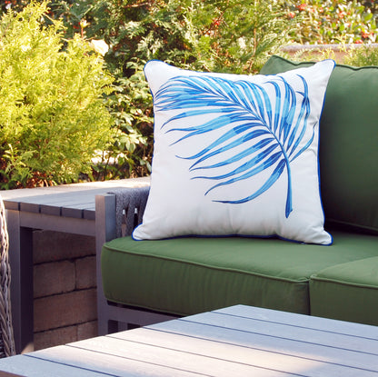Blue Parlor Palm outdoor pillow styled on a green patio couch.