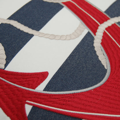 Detail shot of the embroidered red anchor on the Blue Stripe Red Anchor Pillow