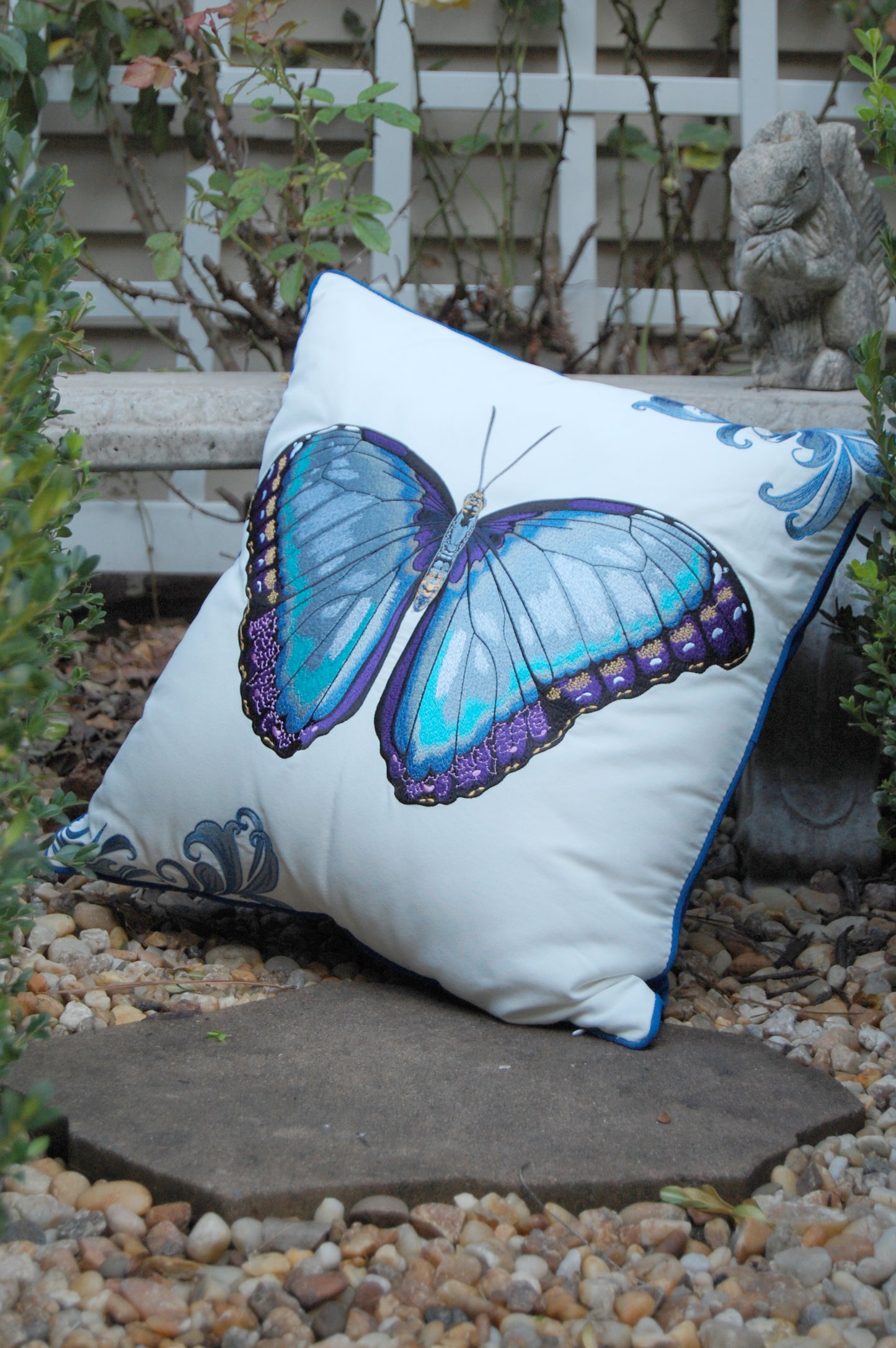 Bold Blue Butterfly outdoor pillow styled in garden.
