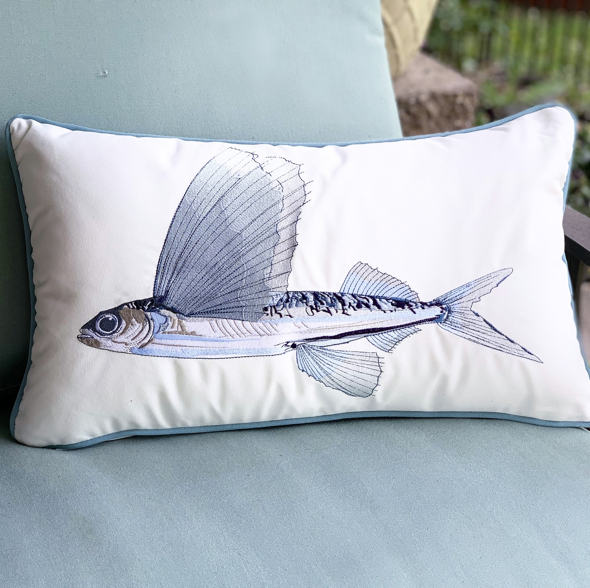 Can't Catch Me Flying Fish pillow styled on an outdoor chair.