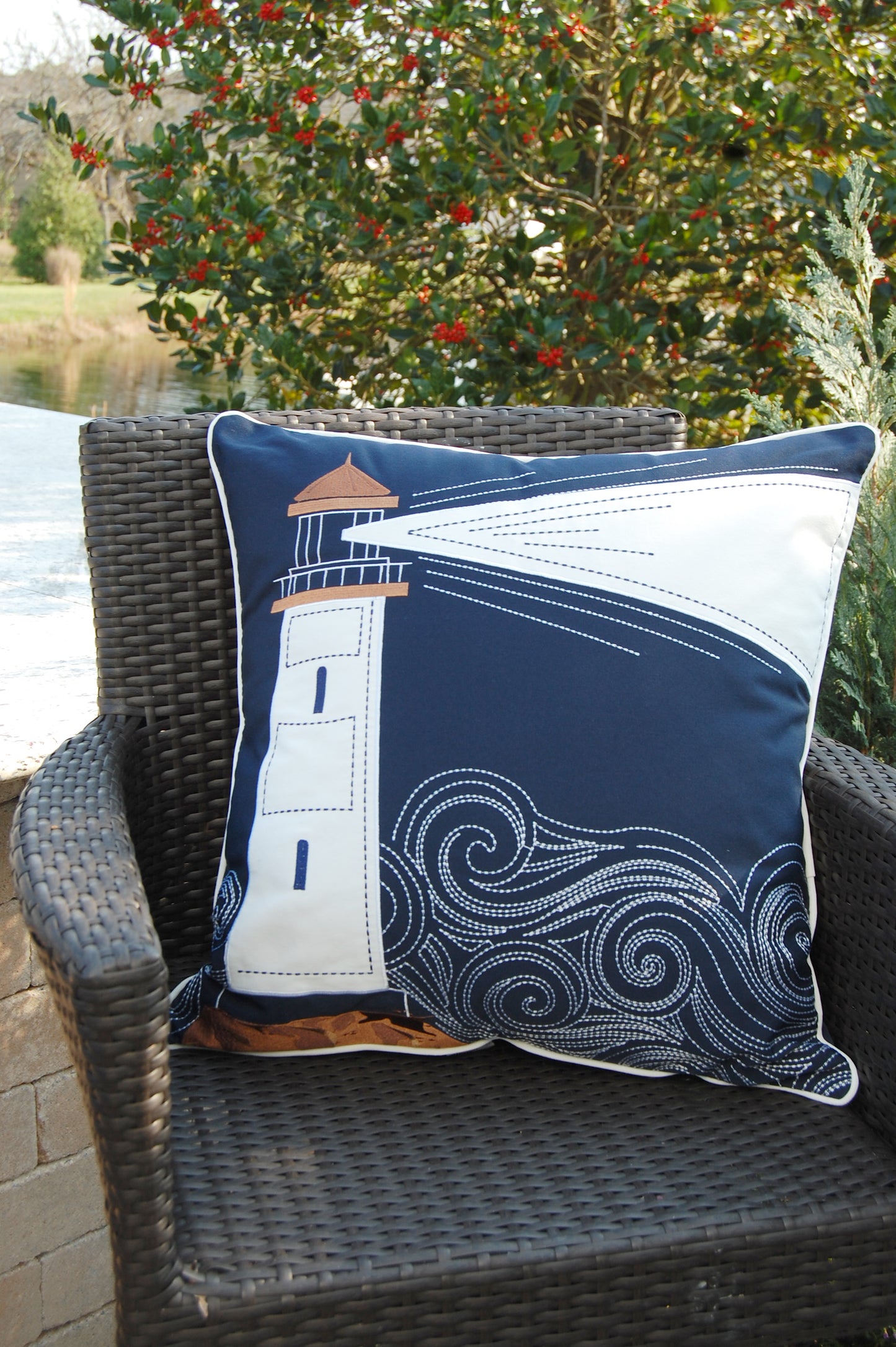 Cape Series Lighthouse pillow styled outside on a patio chair.