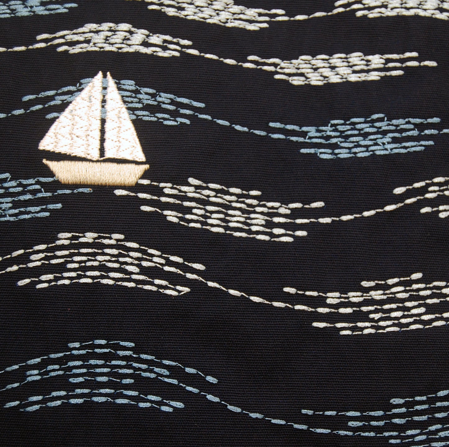 Detailed shot of the embroidered Cape Series Modern Waves pillow