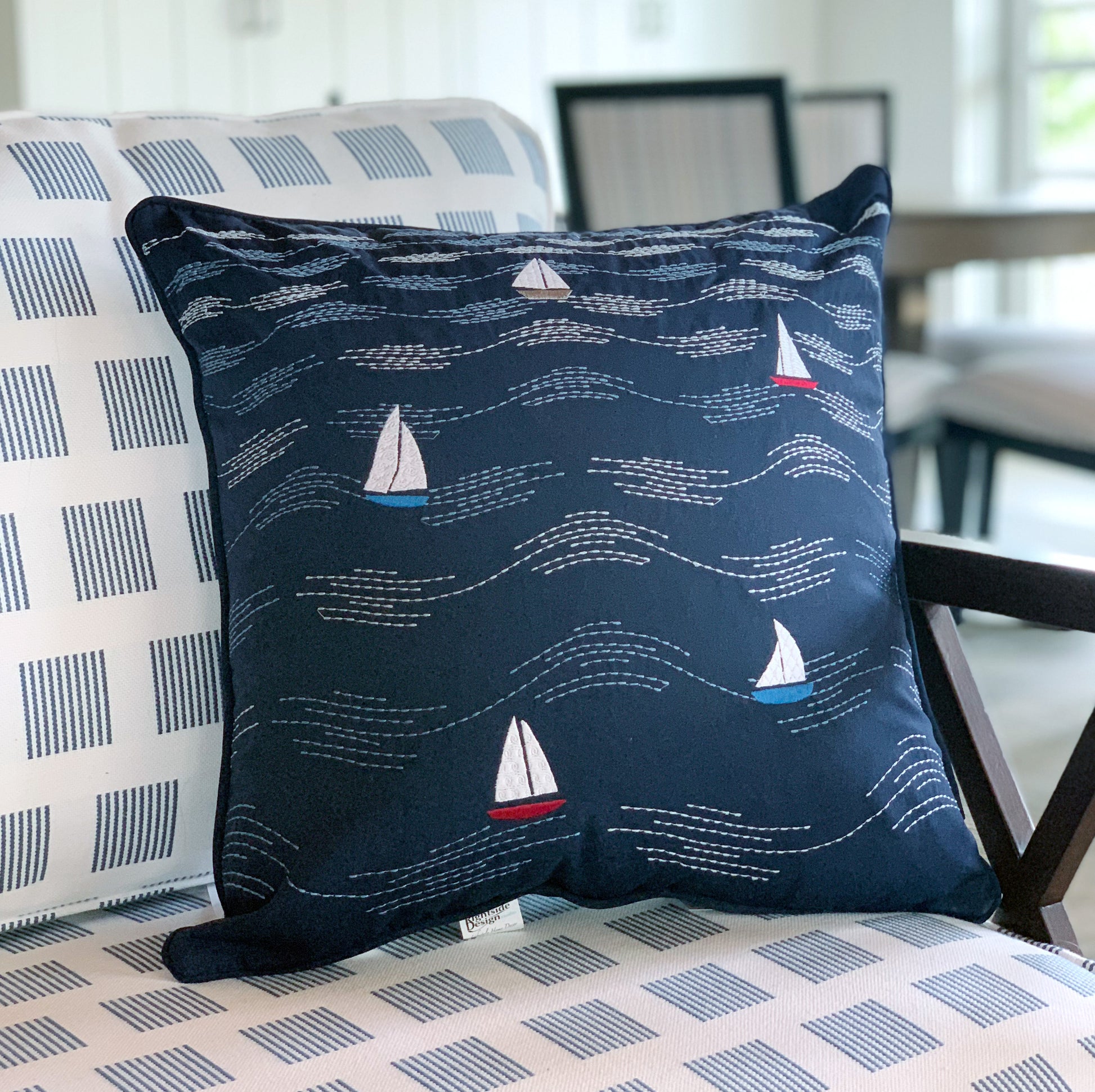 Cape Series Modern Waves pillow styled on patio furniture.