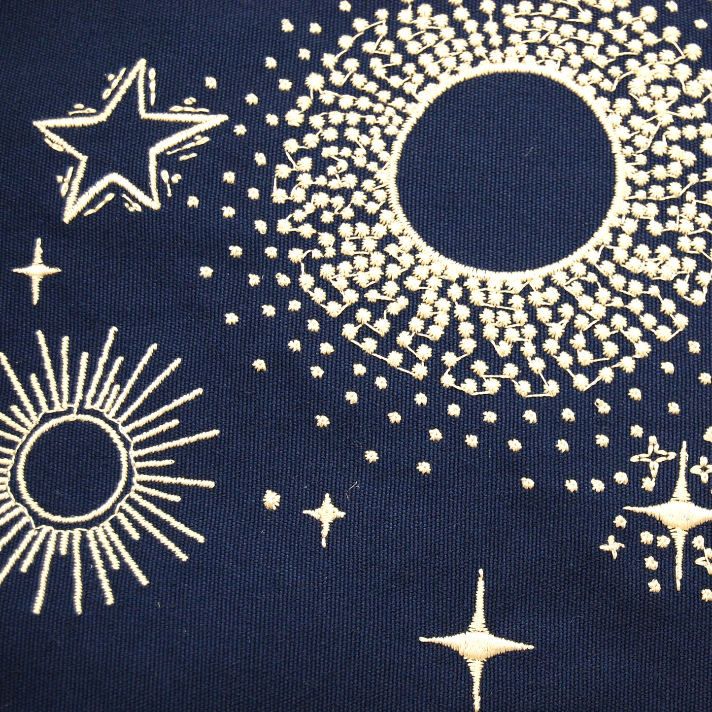 Detail shot of the embroidered stars on the Cape Series Stormy Seas pillow.