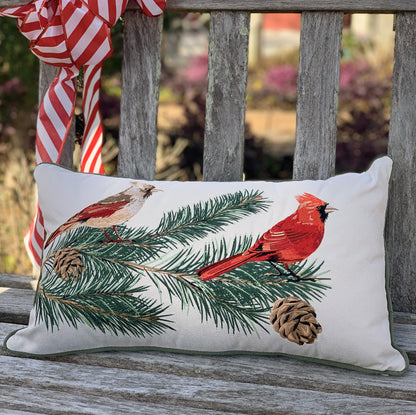 Cardinals and Pines on Beige pillow styled on an outdoor bench.