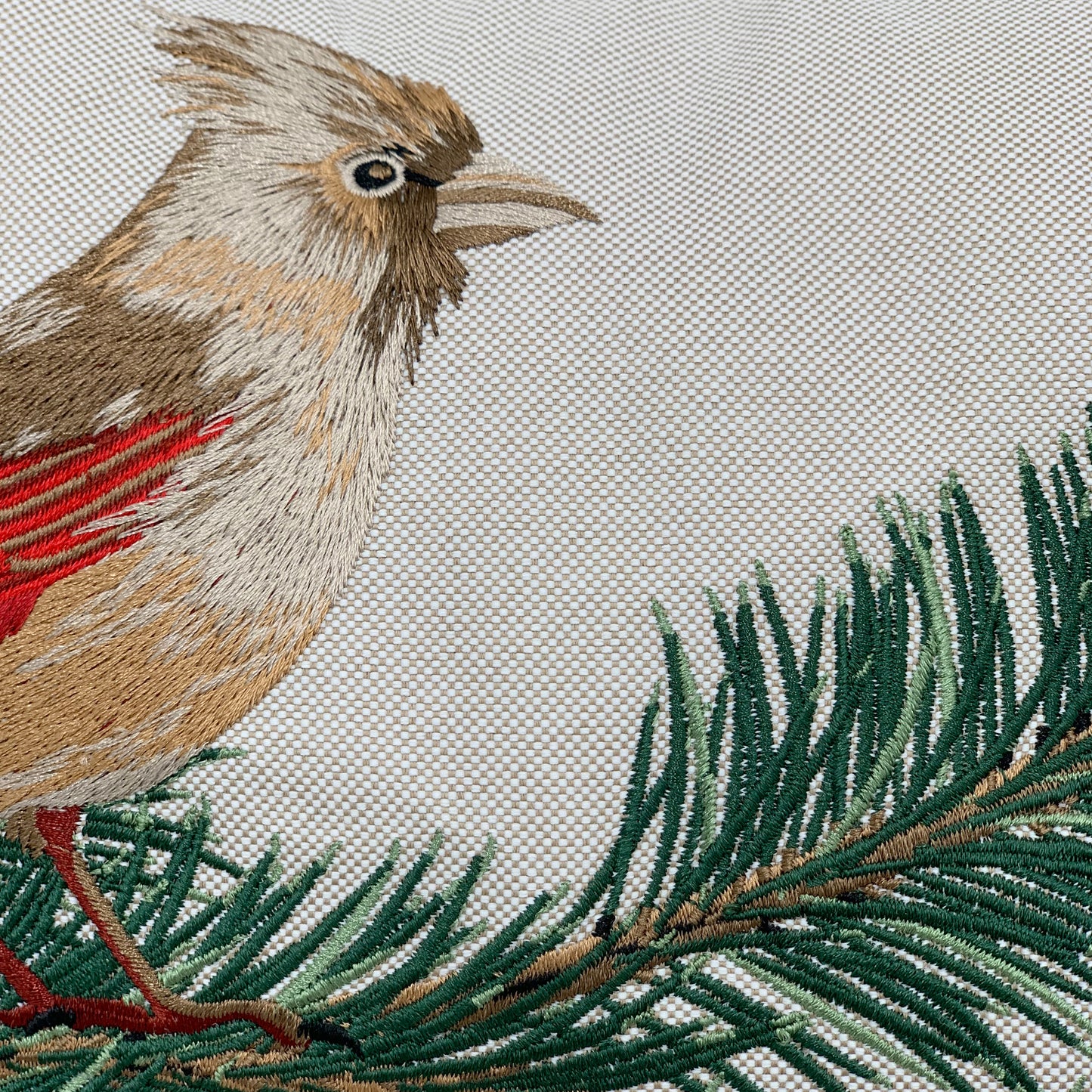 Detail shot of the Cardinals and Pines on Beige pillow embroidery.