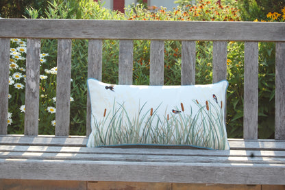 Cattails and Red Winged Blackbird pillow styled on an outdoor bench.