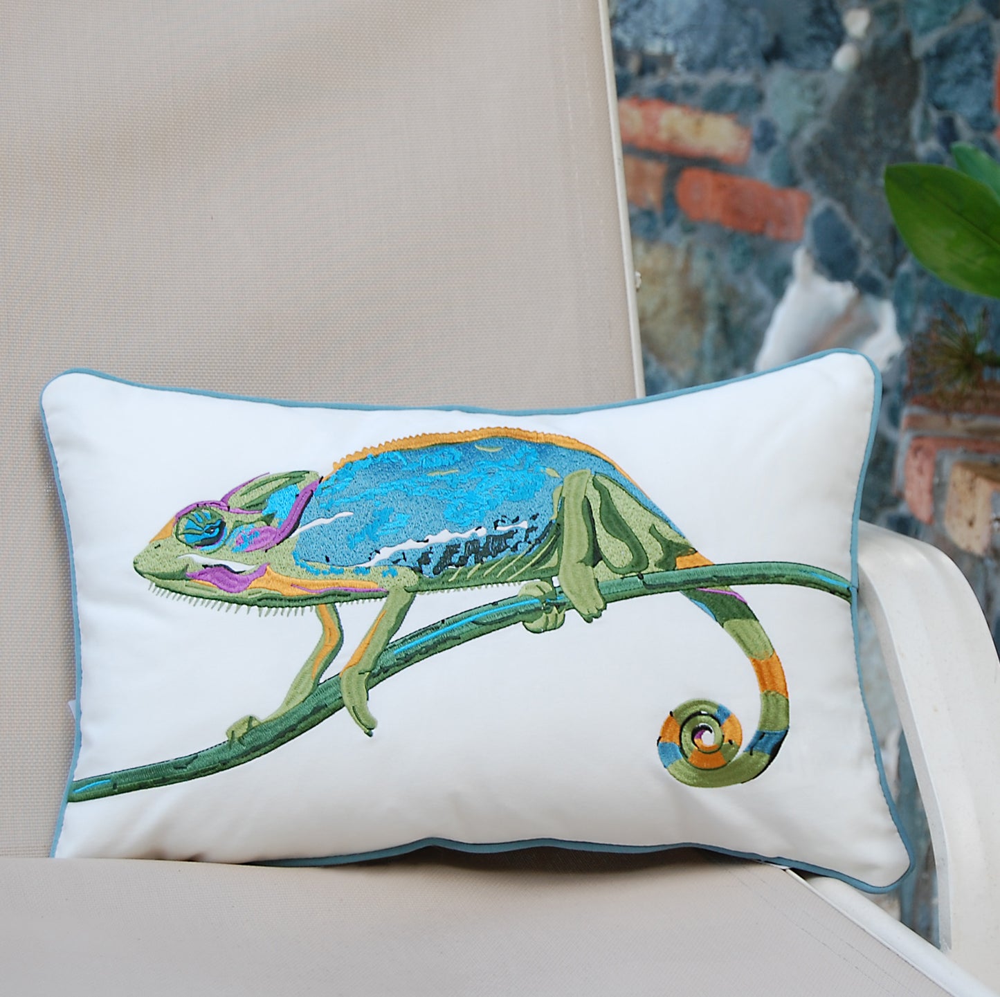 Chameleon pillow styled on an outdoor patio chair.