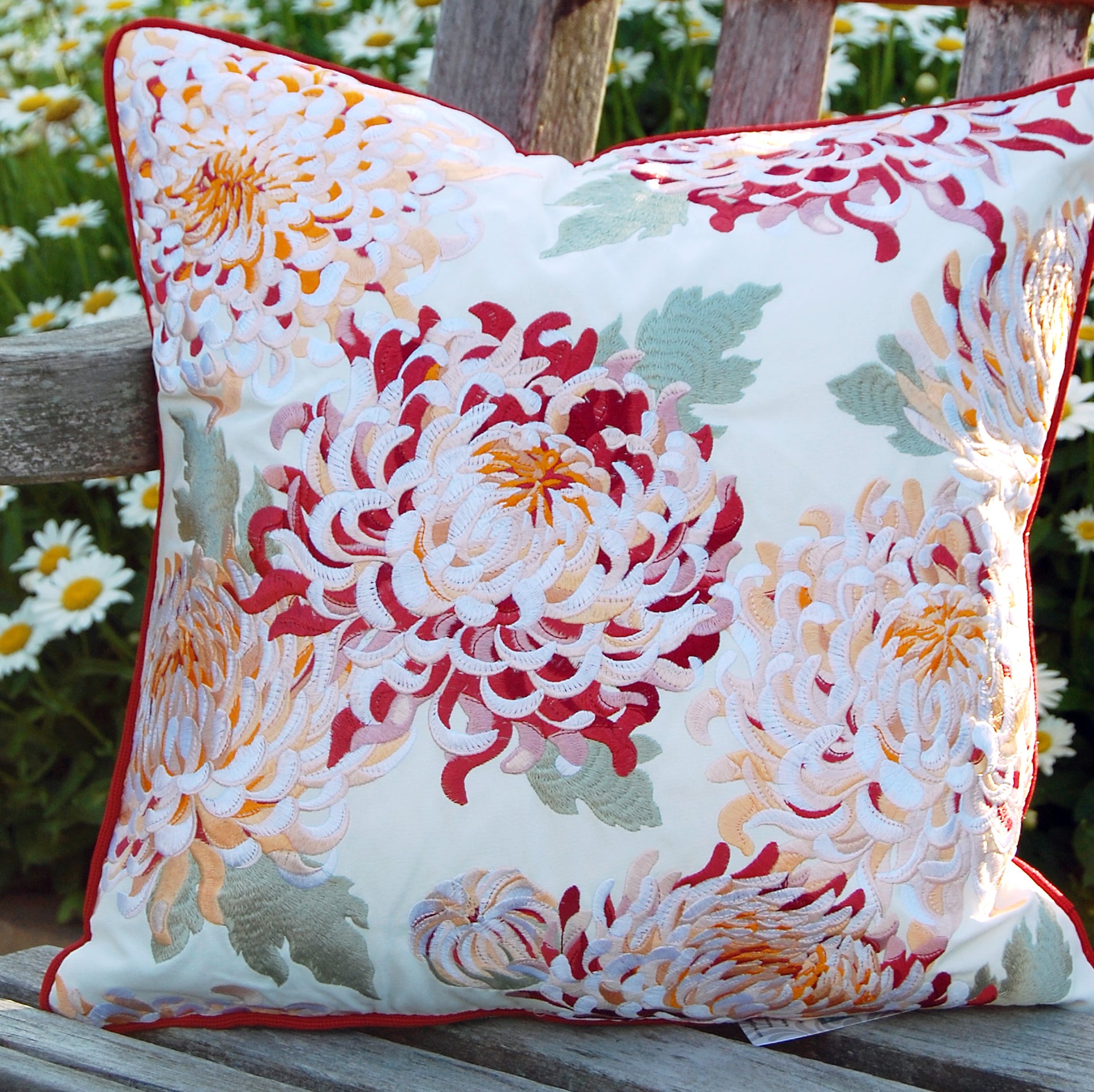 Chrysanthemum pillow styled in a garden on a wooden bench.