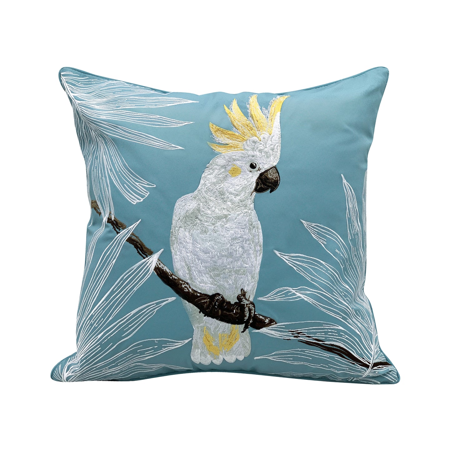 A white and yellow cockatoo sitting on a branch, flanked by tropical palm leaves. Embroidered on a blue background.