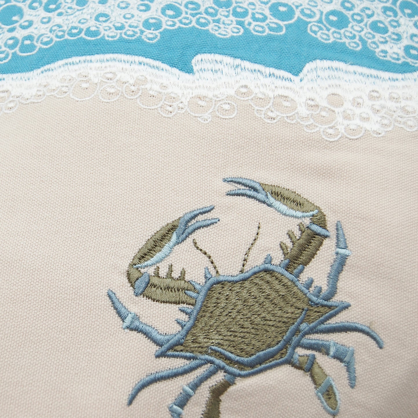 Detail shot of the Crab with Waves pillow embroidery.
