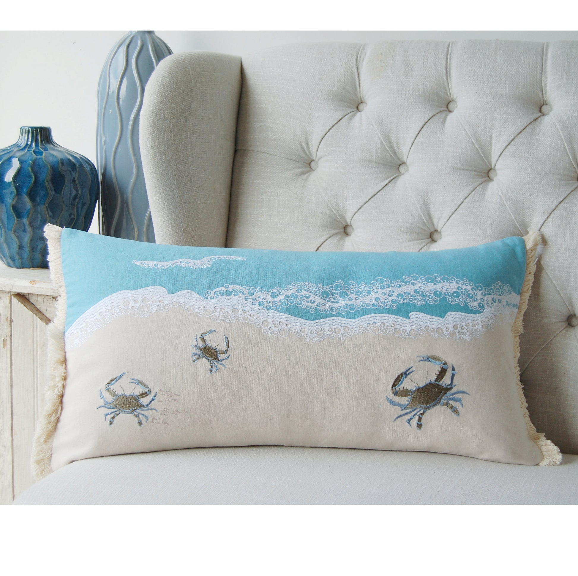 Crab with Waves Fringed Lumbar Pillow styled on a tufted couch.