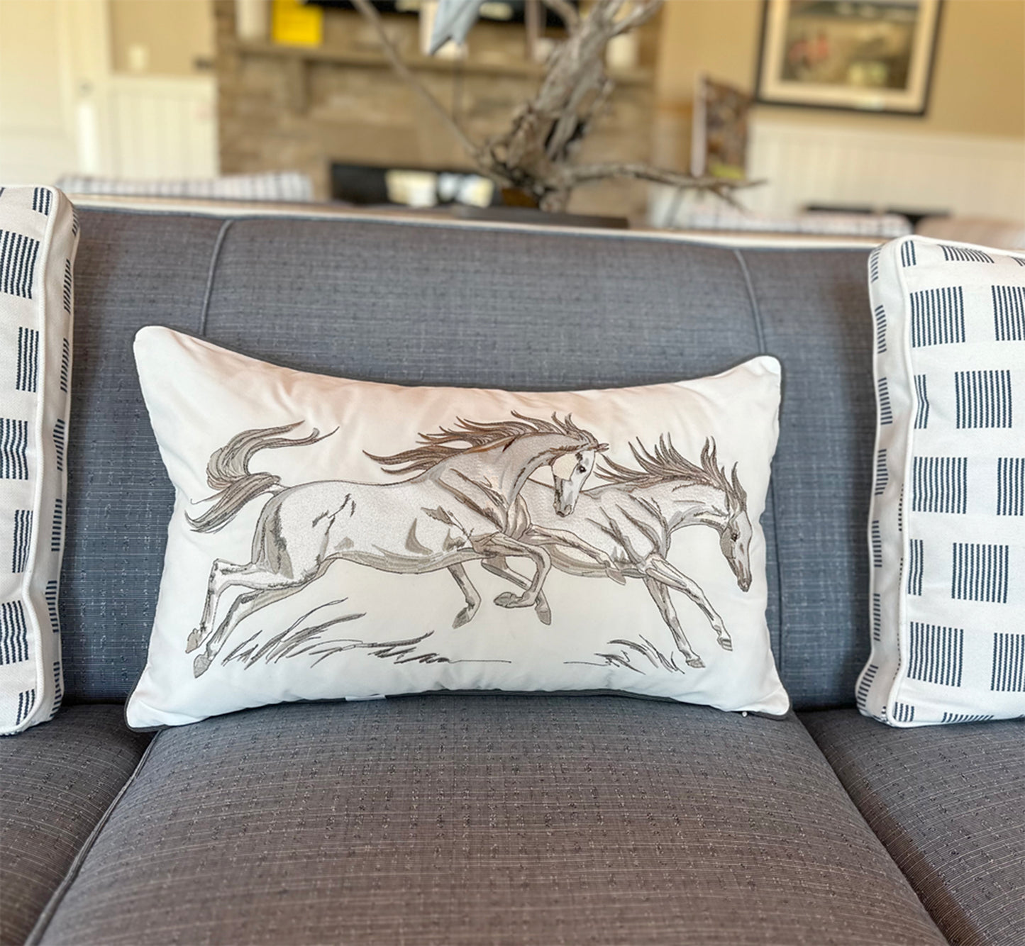 Equine Frolic Lumbar pillow styled on a gray couch.