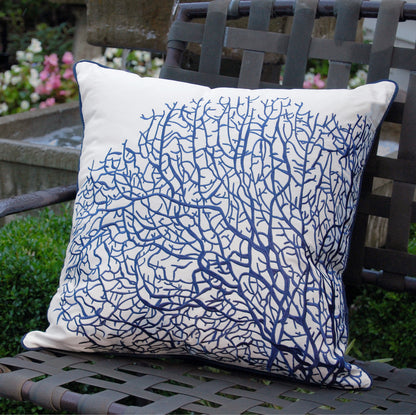 Fan Coral Navy and White pillow styled outdoors on a patio chair.
