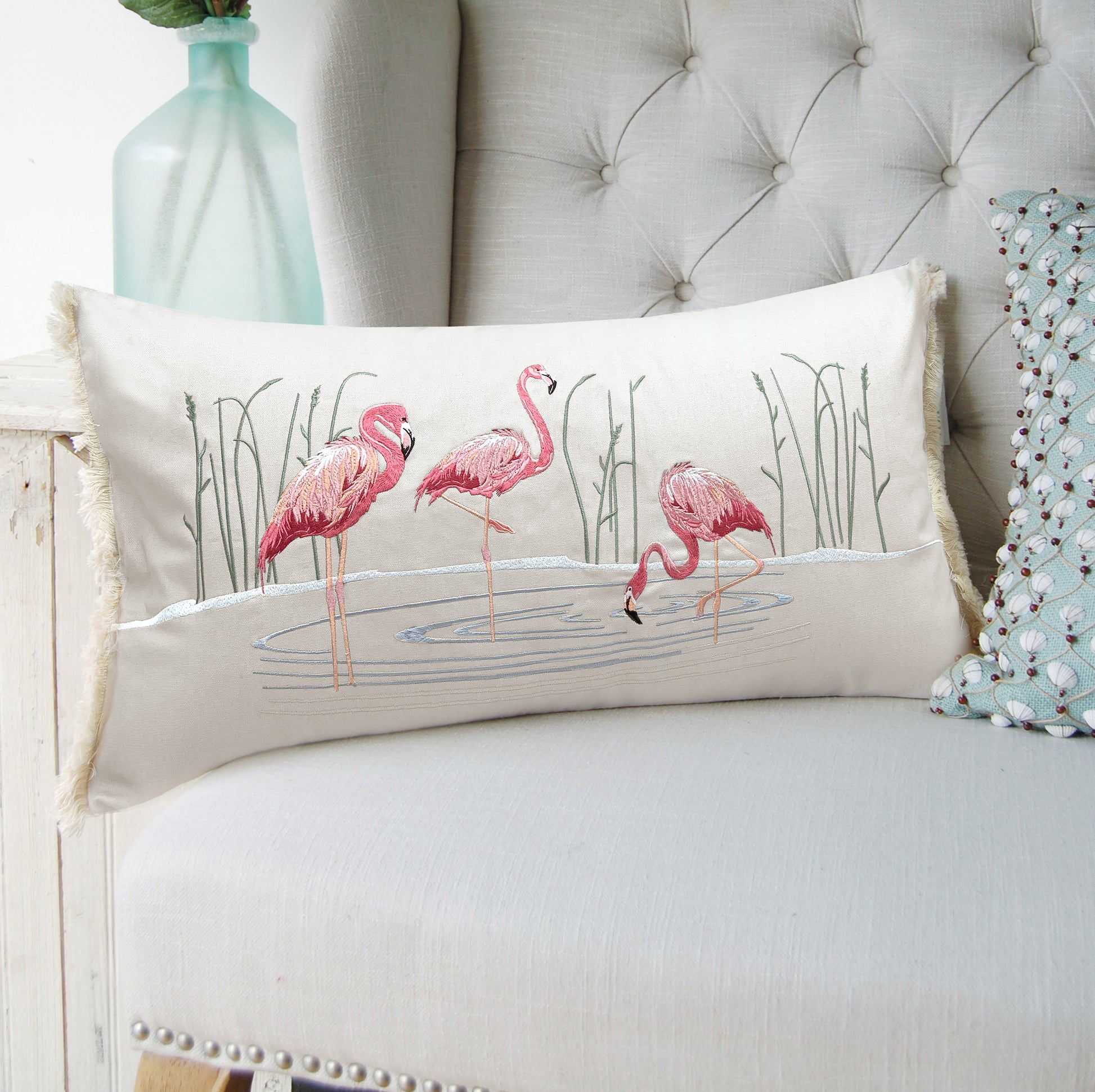 Flamboyant Flamingo pillow styled on a tufted couch.
