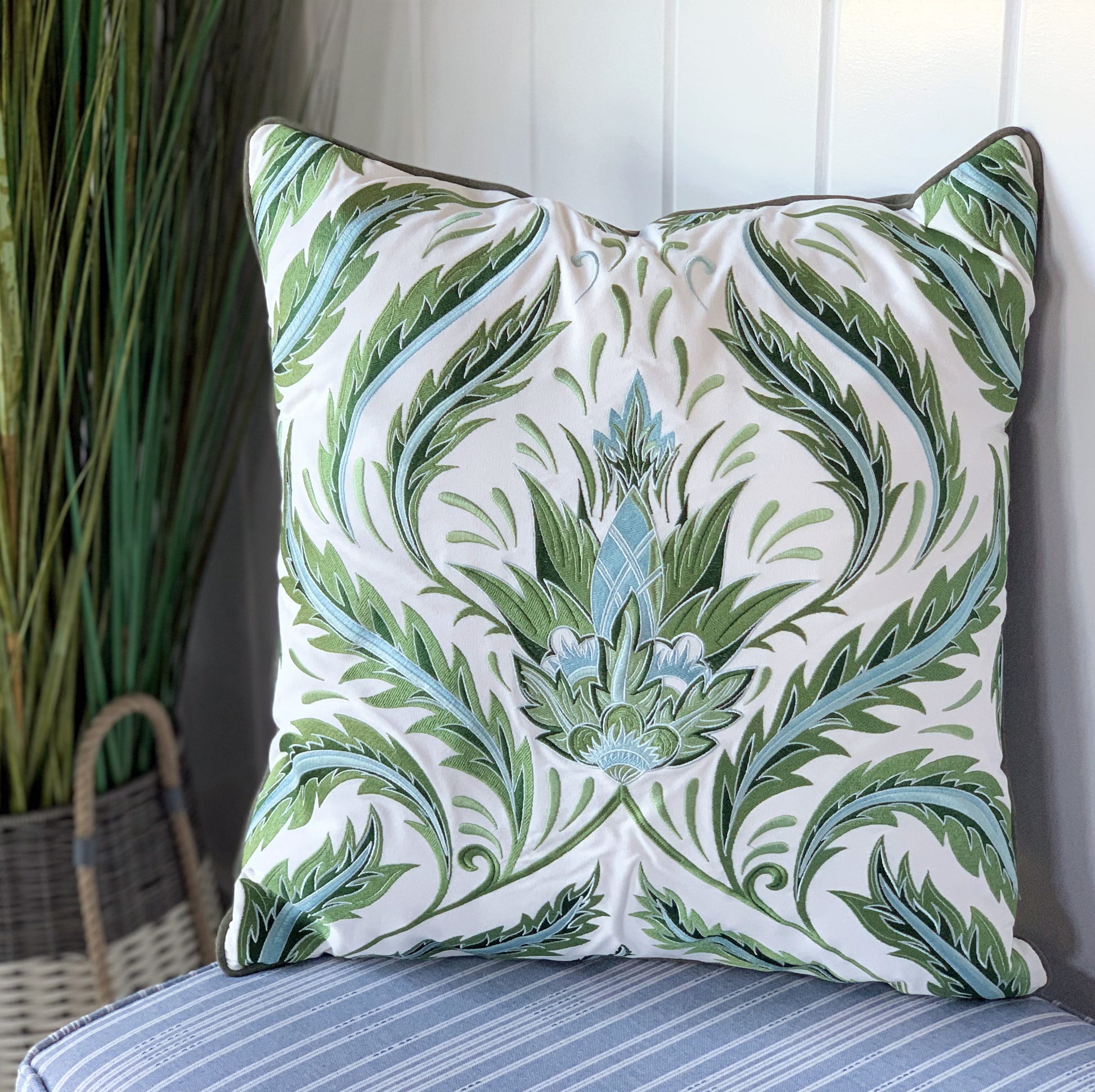 Green Morris Thistle pillow styled on a porch.