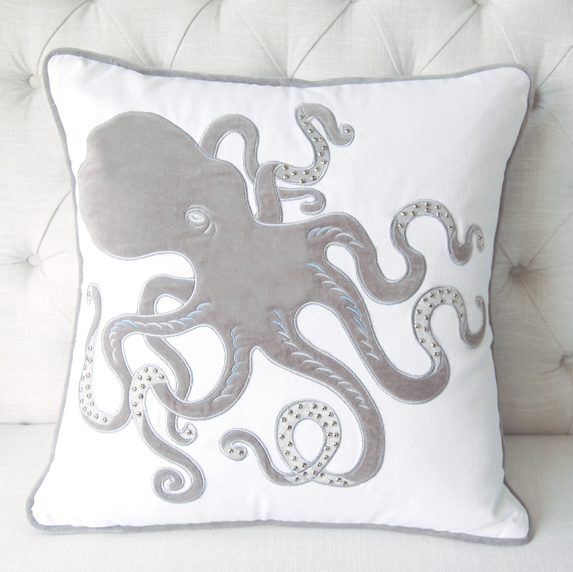 Grey Inkling Octopus pillow styled on a tufted couch.