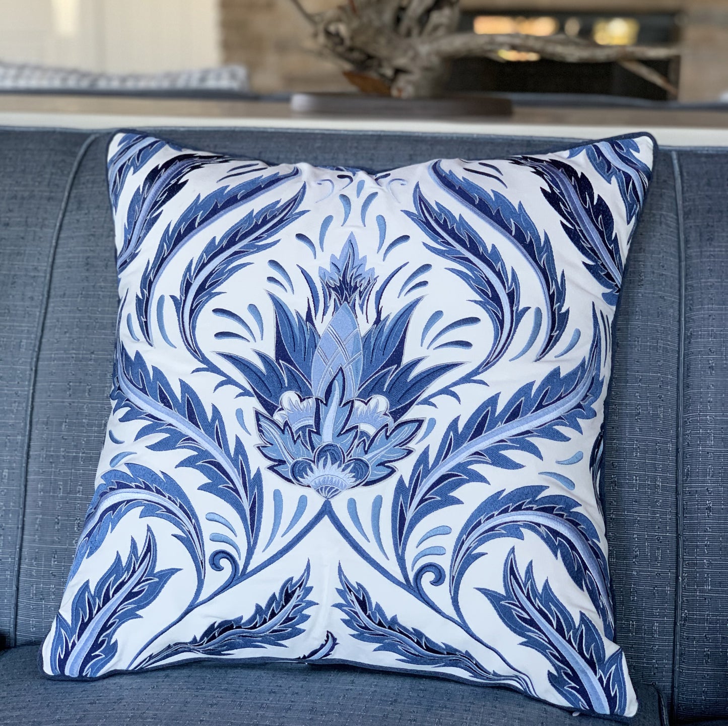 Indigo Morris Thistle indoor styled on a blue sofa.