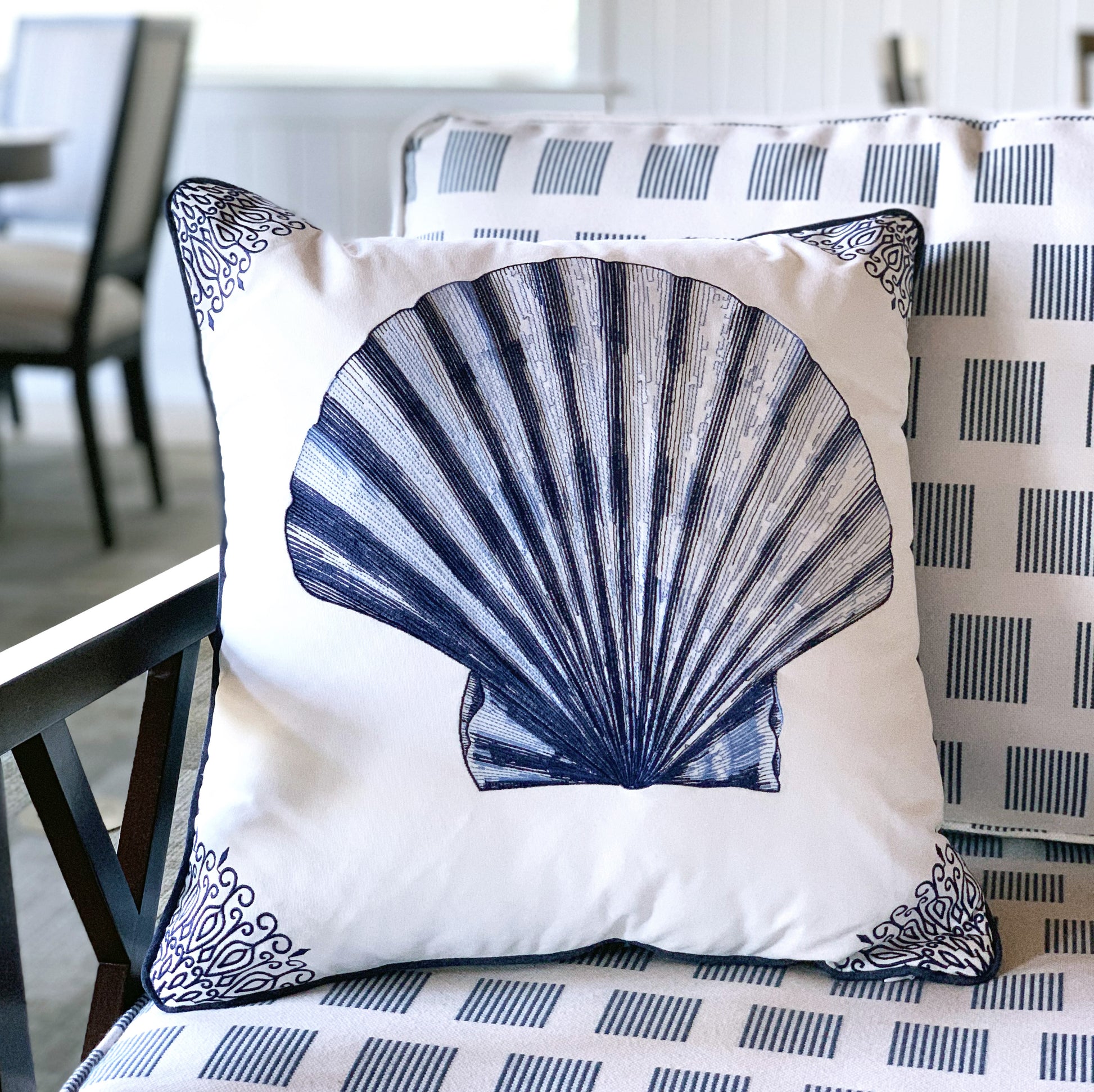 Indigo Scallop Shell pillow styled on a patio chair.