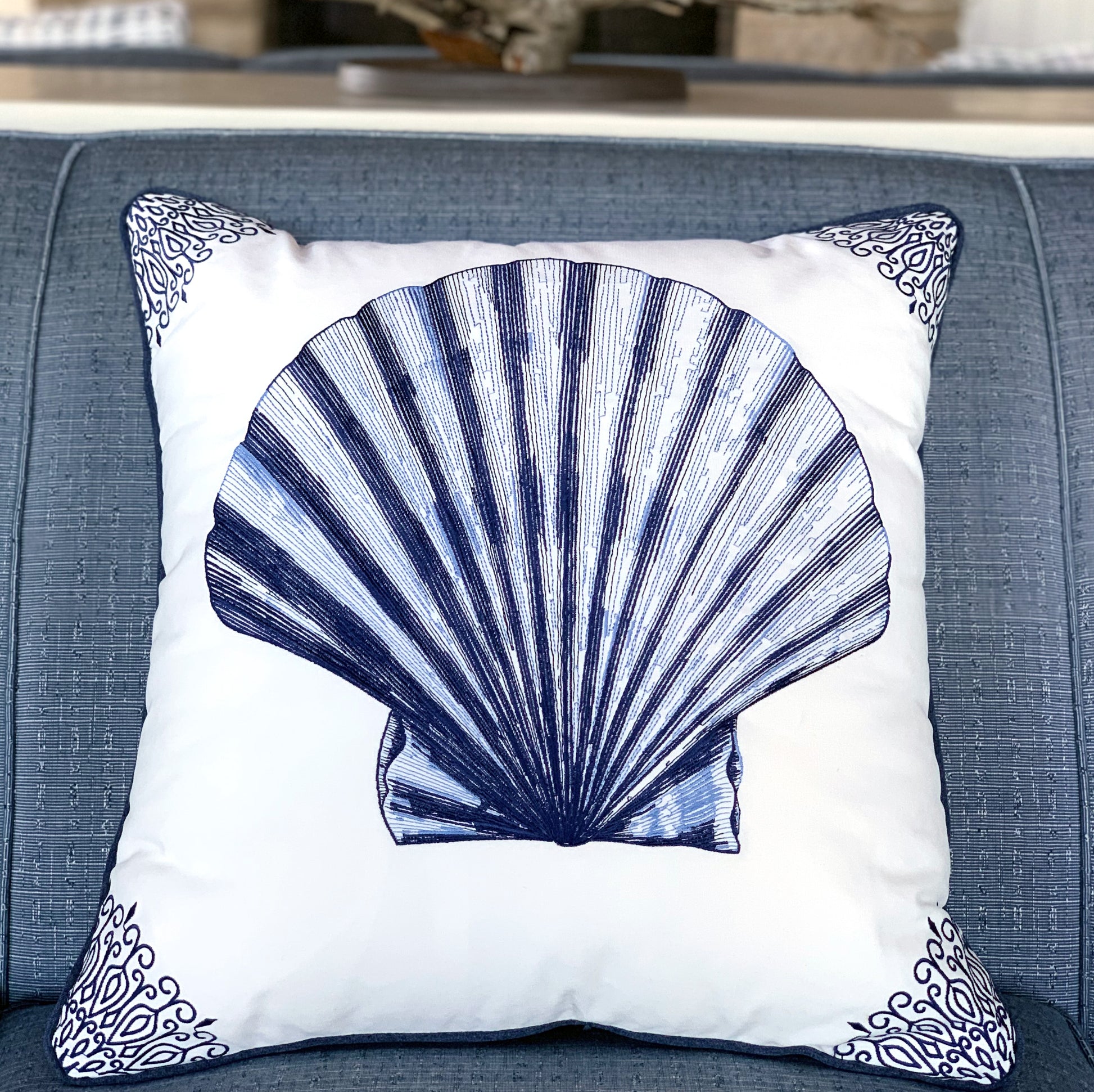 Indigo Scallop Shell pillow styled on a blue sofa.