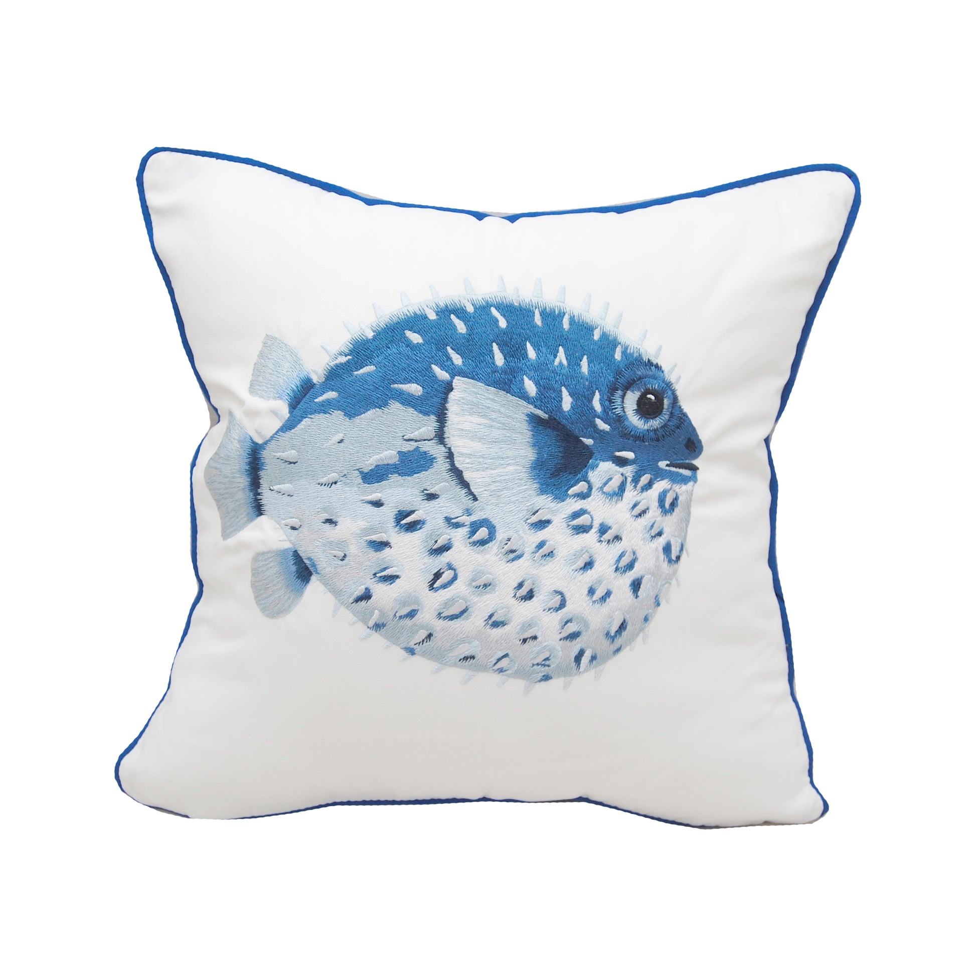 A large pufferfish embroidered in blues and greys on a white background. Pillow is finished with blue piped edging.