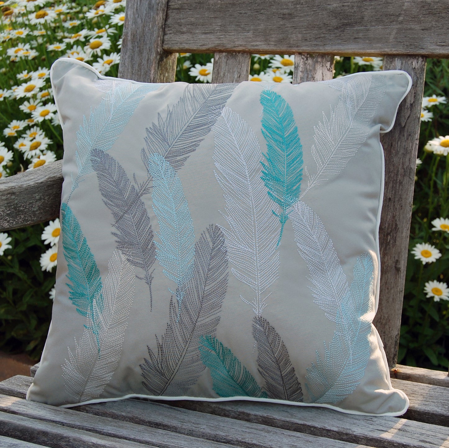 Lake Feather Indoor Outdoor pillow styled on a wooden bench.