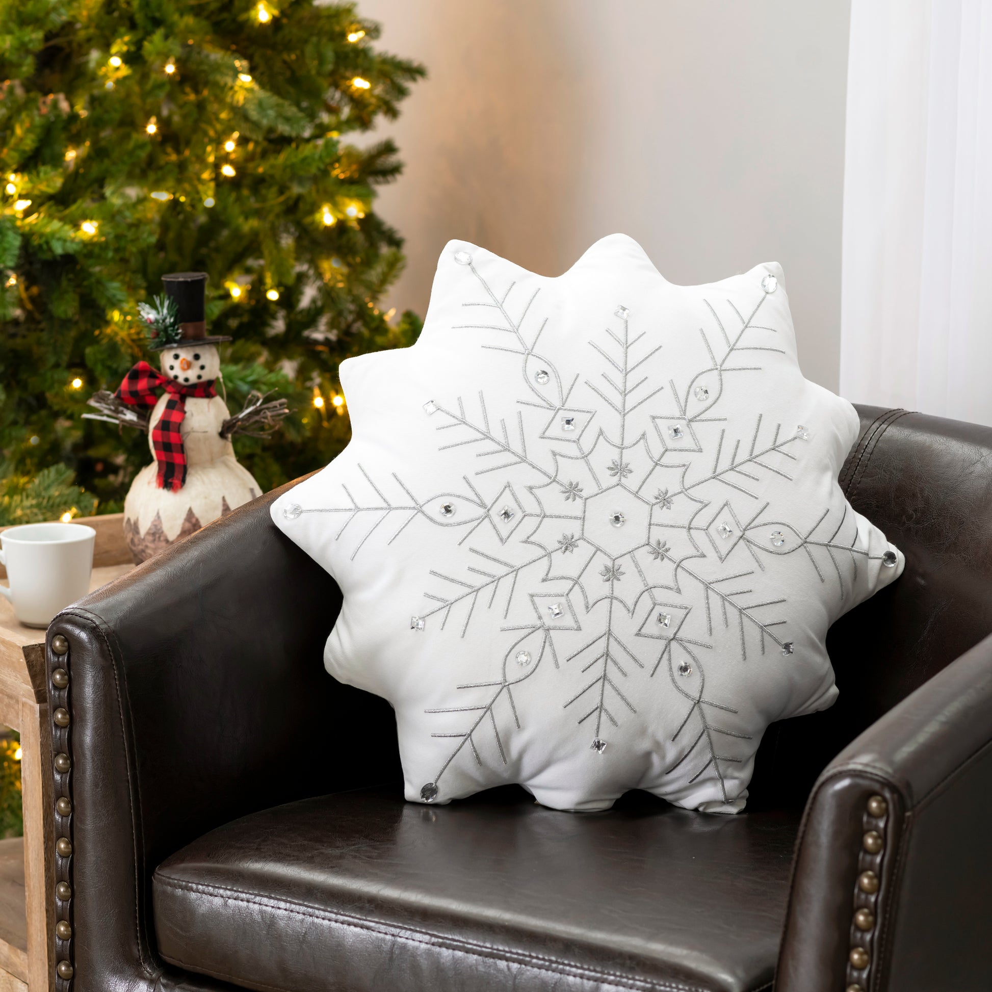 Snowflake Shaped Beaded Large Pillow styled on a holiday themed leather chair.